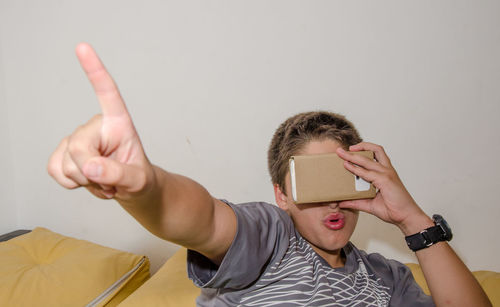 Close-up of boy watching in smart phone through cardboard virtual reality simulator