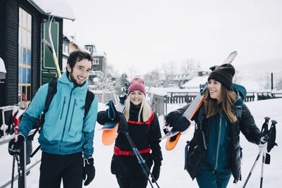 Happy male and female friends walking together during winter