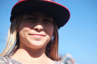 Portrait of smiling woman wearing cap against sky