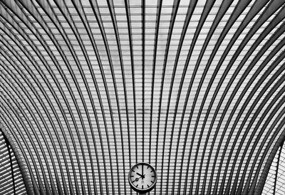 Low angle view of clock against patterned ceiling