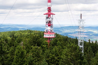 Overhead cable car over forest against sky