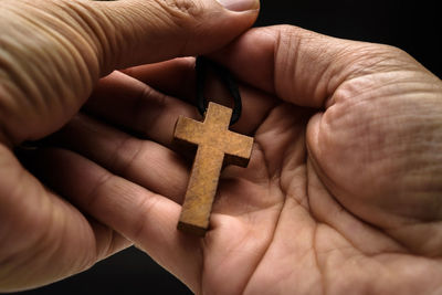 Close-up of human hand holding cross