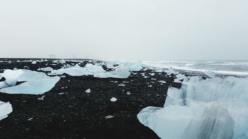 Close-up of snow on sea against clear sky