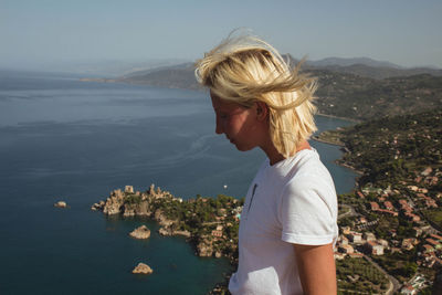 Woman standing by sea against sky