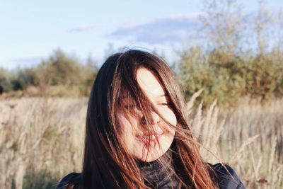 Portrait of beautiful young woman against sky