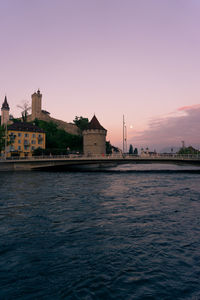 View of buildings at waterfront against sky