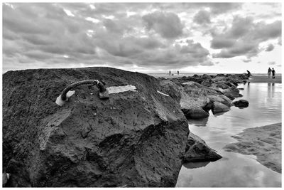 Scenic view of rocks on beach against sky