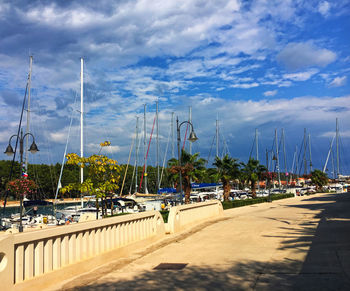 Sailboats moored at harbor against sky