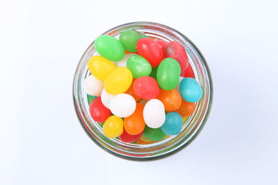 Multi colored candies in bowl against white background