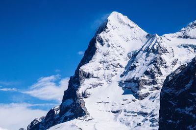 Scenic view of snowcapped mountains against blue sky