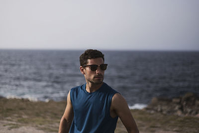 Young man in sunglasses against sea