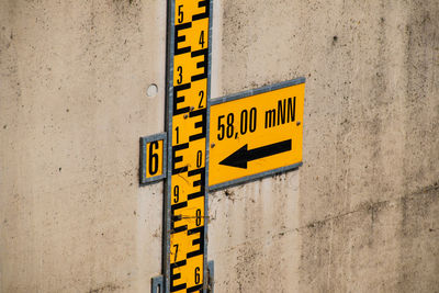 Close-up of yellow sign on wall
