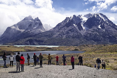 People on snowcapped mountains against sky