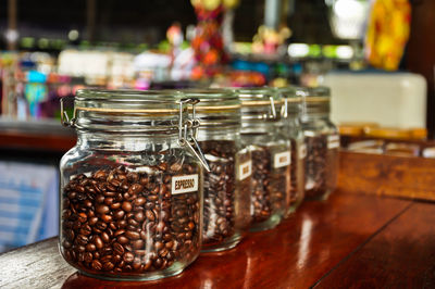 Close-up of coffee beans in jar on wooden table