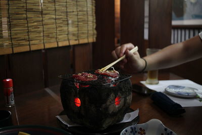 Cropped hand of person preparing food on table