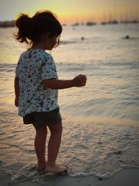 Side view of children standing at beach