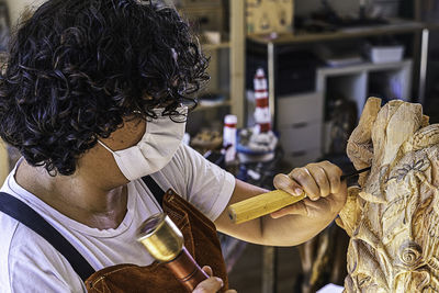 Craftswoman with mask carving wooden figure