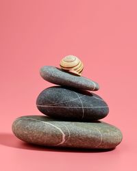 Close-up of stack of stones against pink background