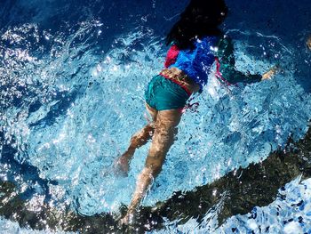 Low section of man swimming in sea