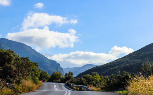 Road amidst trees against sky