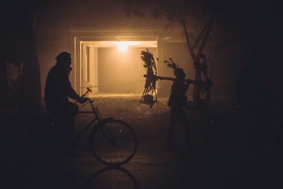 Silhouette men on road at night