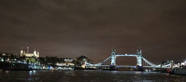 View of suspension bridge in city at night