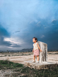 Full length of woman standing on field against sky