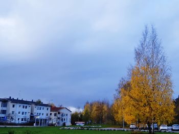Trees and buildings against sky during autumn