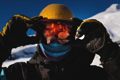 Man in ski goggles. close-up of a young man in a mask in winter on a ski slope on a sunny day