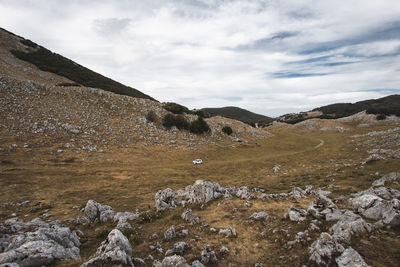 Scenic view of land and mountains against sky