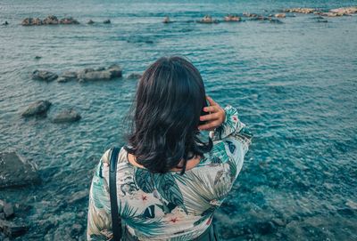 Rear view of woman standing in sea