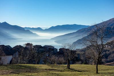 Scenic view of field and mountains against blue sky