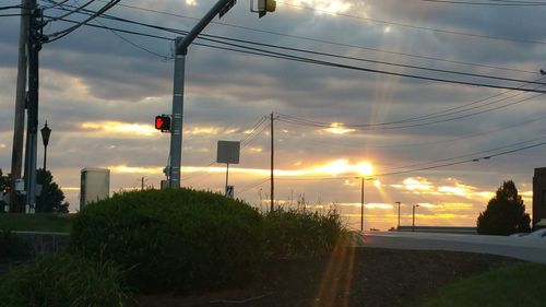 Scenic view of road against cloudy sky at sunset