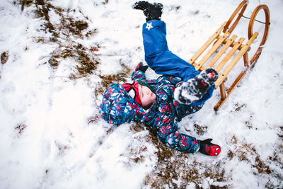 High angle view of child on snow covered land