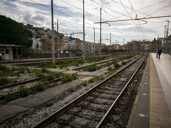 Railway tracks in city against sky