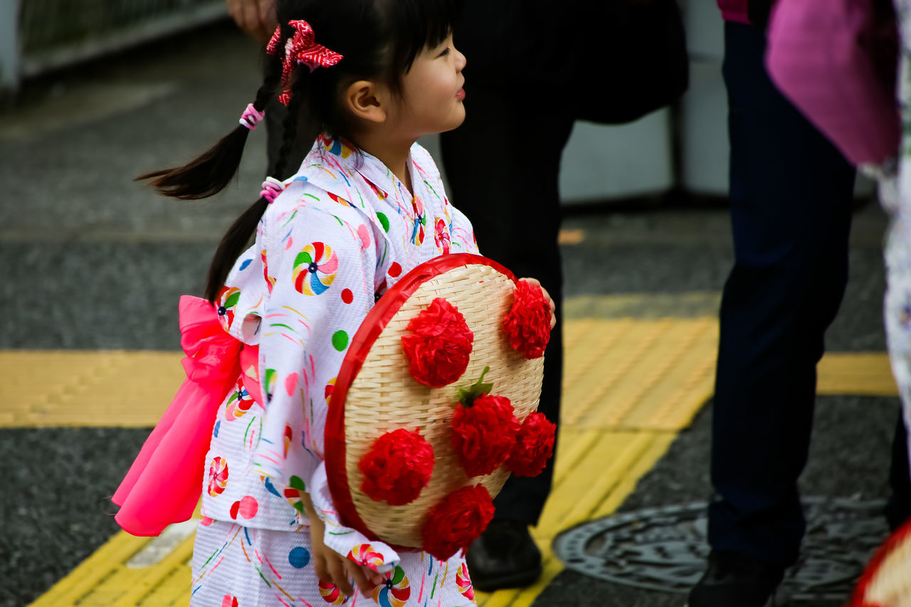 real people, lifestyles, child, women, leisure activity, childhood, girls, incidental people, females, focus on foreground, people, holding, two people, traditional clothing, day, standing, casual clothing, outdoors, floral pattern, innocence