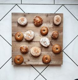 High angle view of donuts with bread on wooden tray 