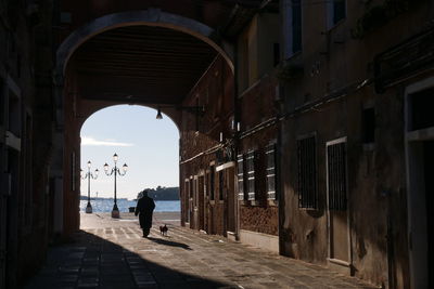 Rear view of people walking in tunnel