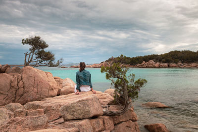 Rear view of man looking at sea against sky