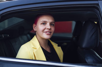 Portrait of smiling young woman sitting in car