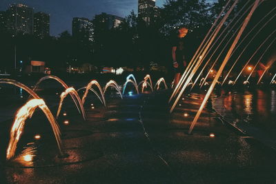 Illuminated fountain in city at night