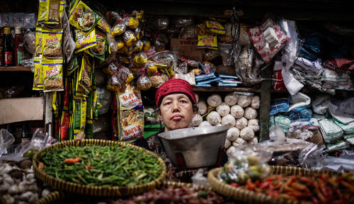 Portrait of woman for sale at market stall