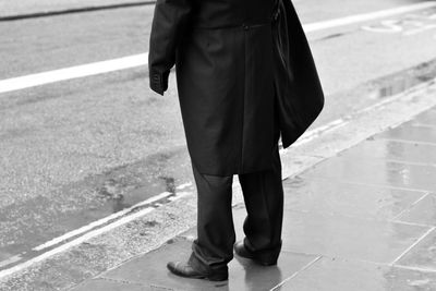 Low section of man standing on road