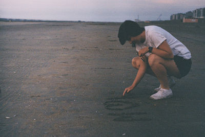 Side view of man playing on beach