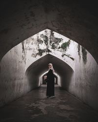 Woman standing in tunnel