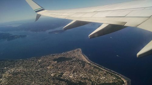 Cropped image of airplane wing over landscape