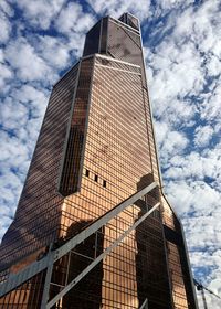Low angle view of modern building against cloudy sky