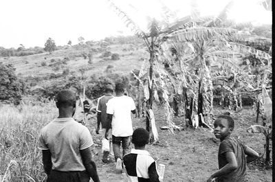 Rear view of people standing on landscape against sky