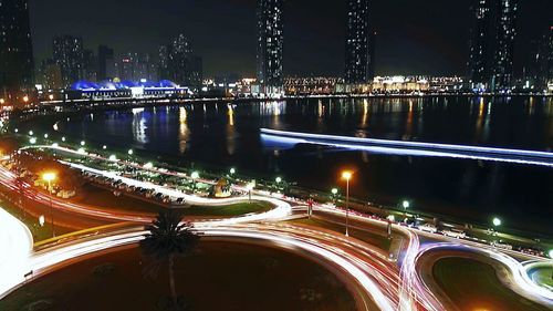 Illuminated bridge and cityscape against sky at night