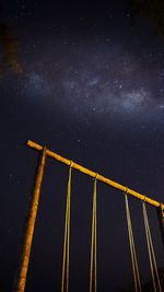 Low angle view of swing against sky at night